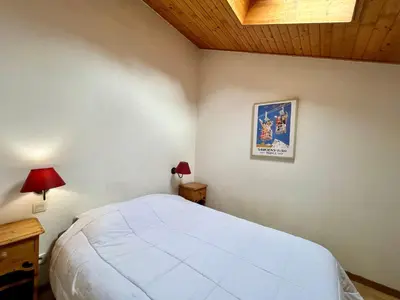 a bedroom with a large white bed and a wooden ceiling at Appartement calme avec piscines chauffée et extérieure - FR-1-624-29 in Samoëns