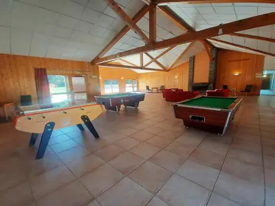 a large room with two pool tables and couches at Appartement calme avec piscines chauffée et extérieure - FR-1-624-29 in Samoëns