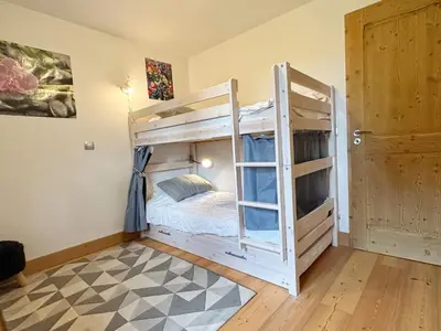 a room with two bunk beds and a door at Charmant T3 au cœur de Samoëns avec jardin, parking et proche ski-bus - FR-1-624-16 in Samoëns