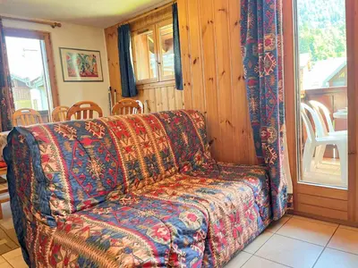 a couch sitting in a living room next to a window at Appartement T2 au cœur du village avec parking - FR-1-624-20 in Samoëns