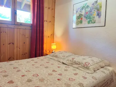 a bedroom with a bed with a pillow and a lamp at Appartement T2 au cœur du village avec parking - FR-1-624-20 in Samoëns