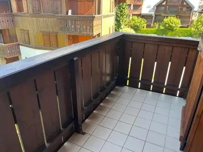 a balcony with a wooden fence and a white tile floor at Appartement T2 au cœur du village avec parking - FR-1-624-20 in Samoëns