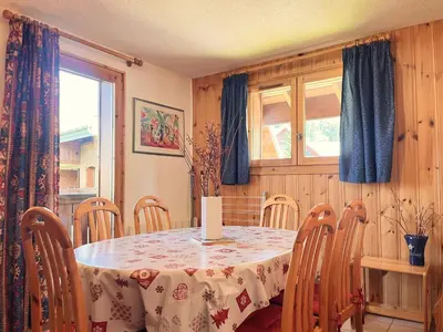 a dining room with a table and chairs and a window at Appartement T2 au cœur du village avec parking - FR-1-624-20 in Samoëns