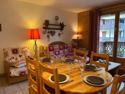 a dining room with a wooden table and chairs at Bel Appartement Central avec Terrasse en Plein Cœur de Samoëns - FR-1-624-19 in Samoëns