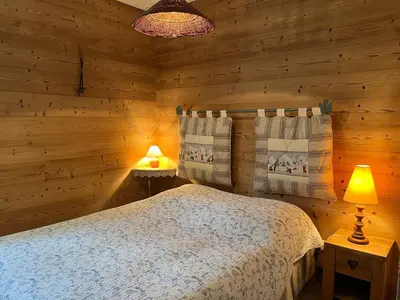 a bedroom with a bed in a log cabin at Bel Appartement Central avec Terrasse en Plein Cœur de Samoëns - FR-1-624-19 in Samoëns