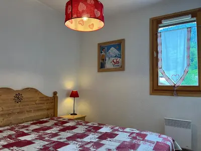 a bedroom with a bed and a window at Bel Appartement Central avec Terrasse en Plein Cœur de Samoëns - FR-1-624-19 in Samoëns