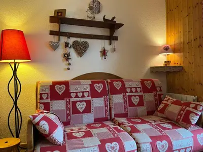 a bedroom with a bed with red and white quilts at Bel Appartement Central avec Terrasse en Plein Cœur de Samoëns - FR-1-624-19 in Samoëns