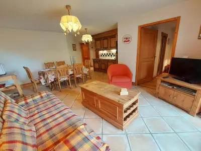 a living room with a couch and a dining room at Appartement T3 au cœur de Samoëns avec terrasse et garage - FR-1-624-28 in Samoëns