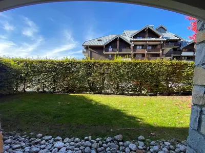 a house is seen through an archway in a yard at Appartement T3 au cœur de Samoëns avec terrasse et garage - FR-1-624-28 in Samoëns