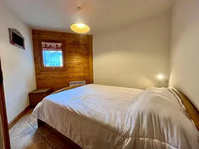 a bedroom with a bed in a room with a window at Appartement T3 au cœur de Samoëns avec terrasse et garage - FR-1-624-28 in Samoëns