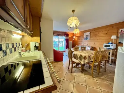 a kitchen and dining room with a table and a sink at Appartement T3 au cœur de Samoëns avec terrasse et garage - FR-1-624-28 in Samoëns