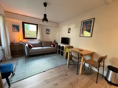 a living room with a couch and a table at Studio lumineux au centre, jardin, parking, casier à skis - FR-1-624-56 in Samoëns