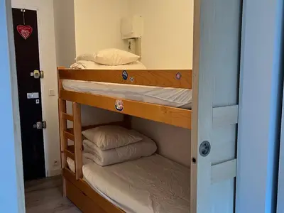 a couple of bunk beds in a room at Studio lumineux au centre, jardin, parking, casier à skis - FR-1-624-56 in Samoëns