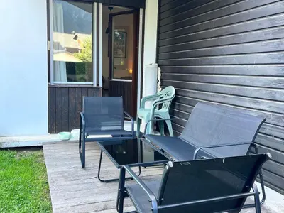 two chairs and a table on a porch at Studio lumineux au centre, jardin, parking, casier à skis - FR-1-624-56 in Samoëns
