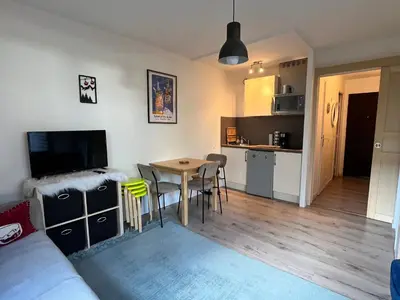 a living room and kitchen with a table and chairs at Studio lumineux au centre, jardin, parking, casier à skis - FR-1-624-56 in Samoëns
