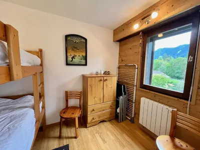 a bedroom with a bunk bed and a window at Bel appartement moderne avec balcon et parking - FR-1-624-59 in Samoëns