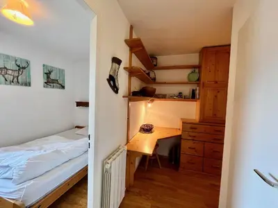 a bedroom with a bed and a desk and a bedroom with a bed at Bel appartement moderne avec balcon et parking - FR-1-624-59 in Samoëns