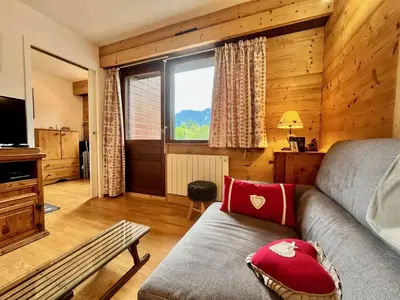 a living room with a couch and a window at Bel appartement moderne avec balcon et parking - FR-1-624-59 in Samoëns