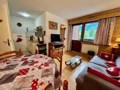 a bedroom with a bed and a couch and a window at Bel appartement moderne avec balcon et parking - FR-1-624-59 in Samoëns
