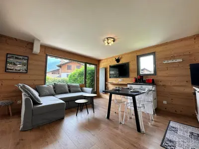 a living room with a couch and a table at Cosy appartement avec jardin privé et WIFI à Samoëns - FR-1-624-47 in Samoëns