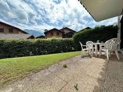 a patio with a table and chairs on a lawn at Cosy appartement avec jardin privé et WIFI à Samoëns - FR-1-624-47 in Samoëns