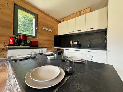 a kitchen with a table with white plates on it at Cosy appartement avec jardin privé et WIFI à Samoëns - FR-1-624-47 in Samoëns