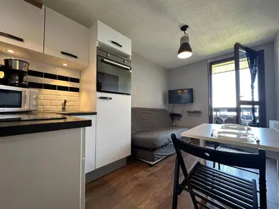 a kitchen and living room with a table and a couch at Studio cosy aux pieds des pistes, vue splendide - FR-1-624-53 in Samoëns