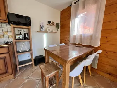 a kitchen with a wooden table and white chairs at Appartement T3 au cœur de Samoëns avec balcon et parking privatif - FR-1-624-54 in Samoëns