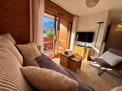 a living room with a couch and a television at Appartement T3 au cœur de Samoëns avec balcon et parking privatif - FR-1-624-54 in Samoëns