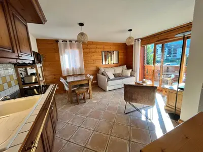 a kitchen and living room with a couch and a table at Appartement T3 au cœur de Samoëns avec balcon et parking privatif - FR-1-624-54 in Samoëns