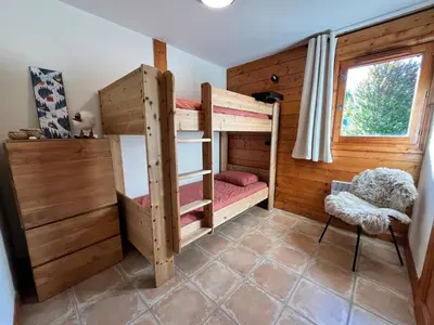 a room with two bunk beds and a window at Appartement T3 au cœur de Samoëns avec balcon et parking privatif - FR-1-624-54 in Samoëns