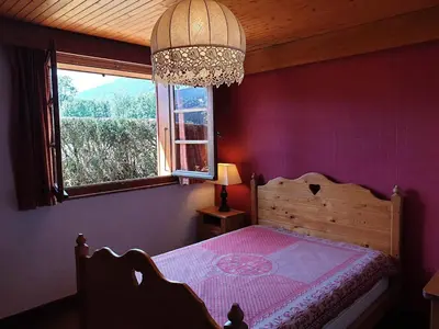 a bedroom with a bed with purple walls and a window at Appartement chalet calme, proche centre, animaux acceptés - FR-1-624-45 in Samoëns
