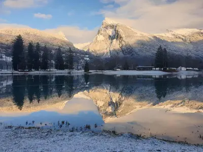 a mountain reflection in a lake with snow covered mountains at Appartement chalet calme, proche centre, animaux acceptés - FR-1-624-45 in Samoëns