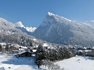 a village in the snow with a mountain in the background at Studio duplex lumineux au centre de Samoëns avec parking - FR-1-624-58 in Samoëns
