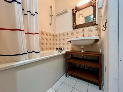a bathroom with a sink and a tub and a mirror at Studio duplex lumineux au centre de Samoëns avec parking - FR-1-624-58 in Samoëns