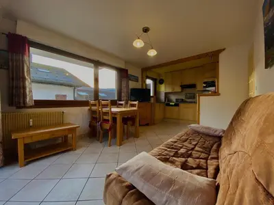 a living room with a couch and a table and a kitchen at Appartement T2 avec balcon au centre de Samoëns - FR-1-624-44 in Samoëns