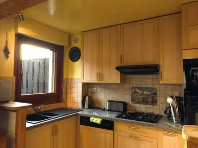 a kitchen with wooden cabinets and a sink and a window at Appartement T2 avec balcon au centre de Samoëns - FR-1-624-44 in Samoëns