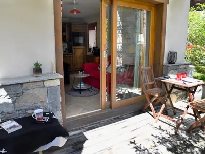 a patio with a stone fireplace and a living room at Superbe appartement au centre de Samoëns avec terrasse - FR-1-624-46 in Samoëns