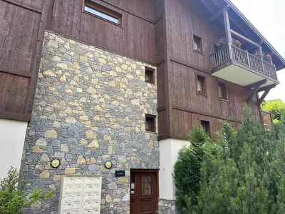 a building with a balcony on the side of it at Superbe appartement au centre de Samoëns avec terrasse - FR-1-624-46 in Samoëns