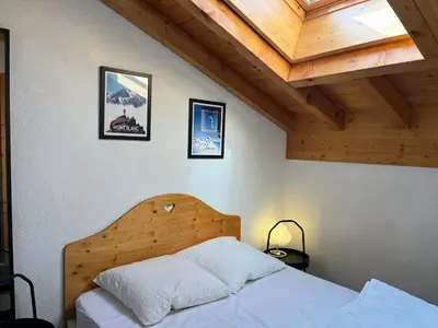 a bedroom with a bed and a wooden ceiling at Charmant T2 en centre-ville avec balcon et animaux acceptés - FR-1-624-43 in Samoëns