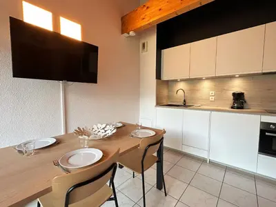a kitchen with a wooden table with chairs and a sink at Charmant T2 en centre-ville avec balcon et animaux acceptés - FR-1-624-43 in Samoëns