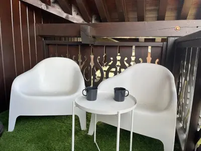two white chairs and a table with two mugs on it at Charmant T2 en centre-ville avec balcon et animaux acceptés - FR-1-624-43 in Samoëns