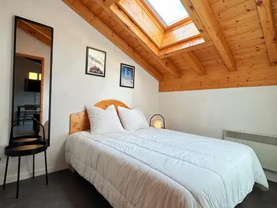 a bedroom with a large white bed with a skylight at Charmant T2 en centre-ville avec balcon et animaux acceptés - FR-1-624-43 in Samoëns