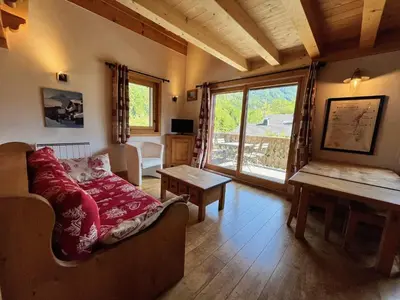 a living room with a couch and a large window at Appartement T3 confortable proche centre avec balcon et parking - FR-1-624-42 in Samoëns
