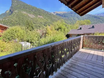 a wooden balcony with a view of a mountain at Appartement T3 confortable proche centre avec balcon et parking - FR-1-624-42 in Samoëns