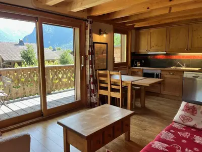 a kitchen with a dining table and a balcony at Appartement T3 confortable proche centre avec balcon et parking - FR-1-624-42 in Samoëns