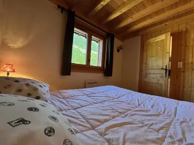 a bed in a room with a window and a bed sidx sidx at Appartement T3 confortable proche centre avec balcon et parking - FR-1-624-42 in Samoëns