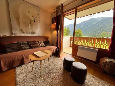 a bedroom with a bed and a table and a balcony at Appartement T2 avec Balcon et Parking à Samoëns - FR-1-624-37 in Samoëns