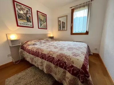 a bedroom with a bed and two pictures on the wall at Appartement T2 avec Balcon et Parking à Samoëns - FR-1-624-37 in Samoëns