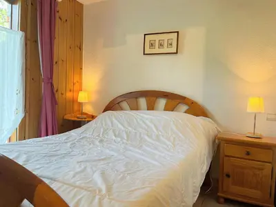 a bedroom with a bed with white sheets and two lamps at Appartement T2 avec jardinet proche du centre, Wi-Fi, garage - FR-1-624-61 in Samoëns